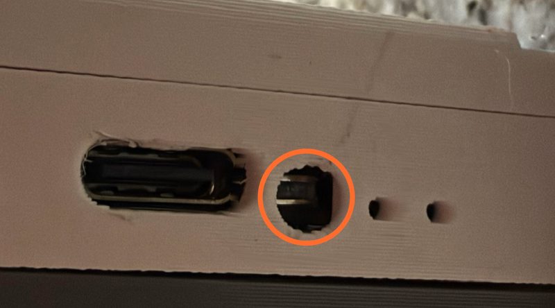 The side of the base: the USB-C port, and just to its right the small round reset button, circled.